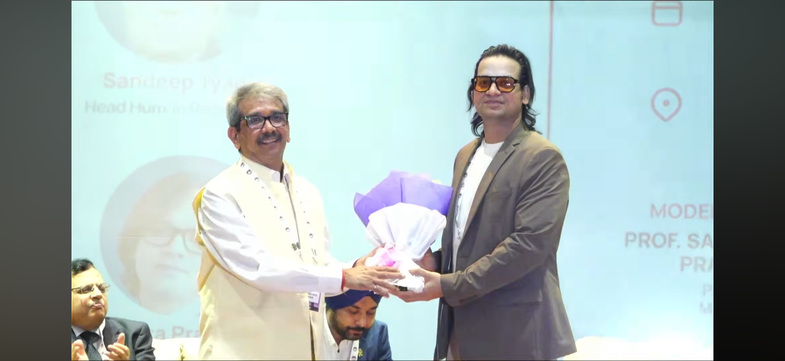 Shivendra receiving a bouquet at IIM Raipur
